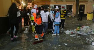 Una limpiadora recoge la suciedad de la calle en el Carnaval de Cádiz. Desalojo Viña Polémica